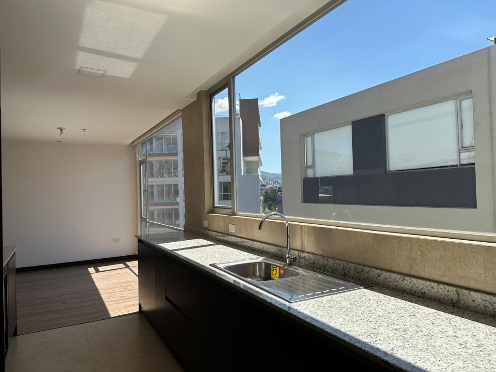 Cocina con mesón en granito y vista exterior